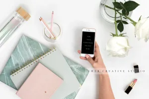 Hand Holding Smartphone and Desk Accessories